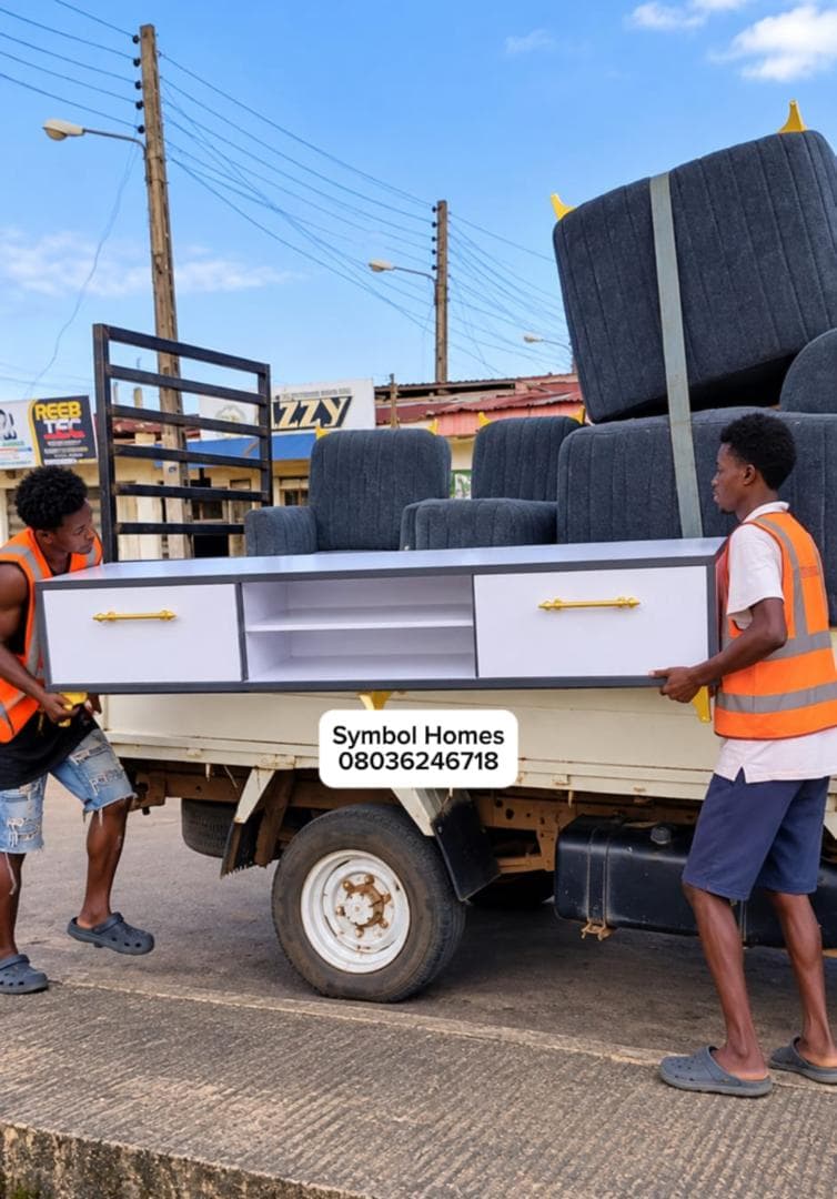 Symbol Homes crew loading a white TV console onto the delivery truck