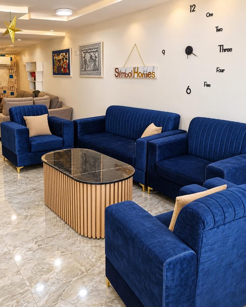 Symbol Homes showroom with blue sofas, wall clock and warm lighting