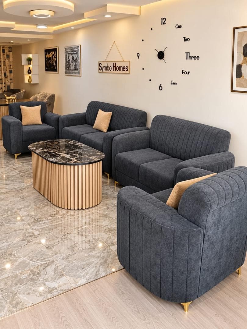Charcoal fluted sofa set with gold legs around a marble-top fluted oak coffee table in the Symbol Homes showroom