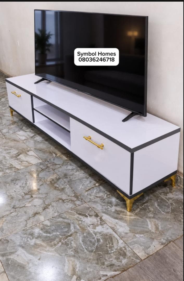 White TV console with dark edging, gold handles and gold legs
