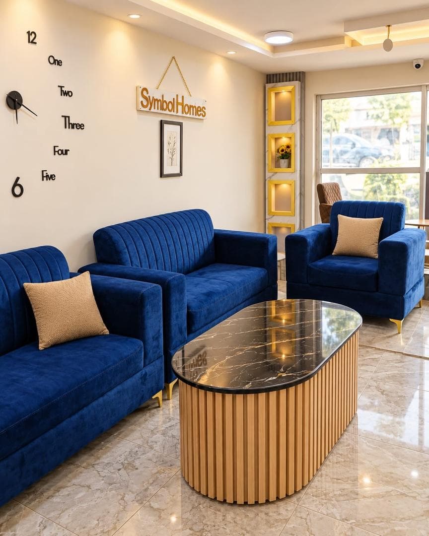 Blue velvet sofas around a fluted oak coffee table near a bright window